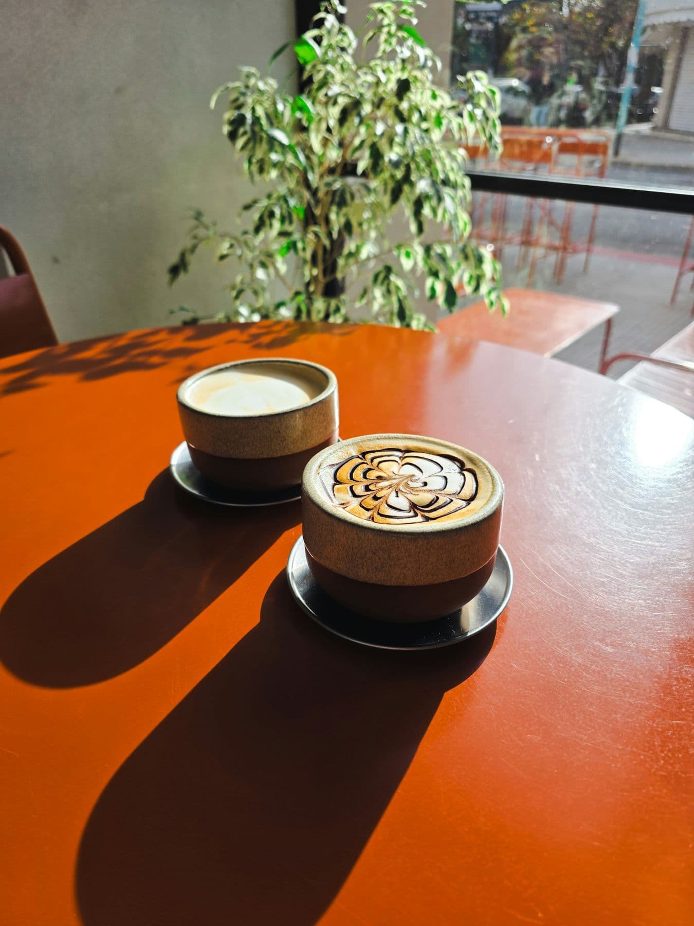 Dois cafés numa mesa laranja